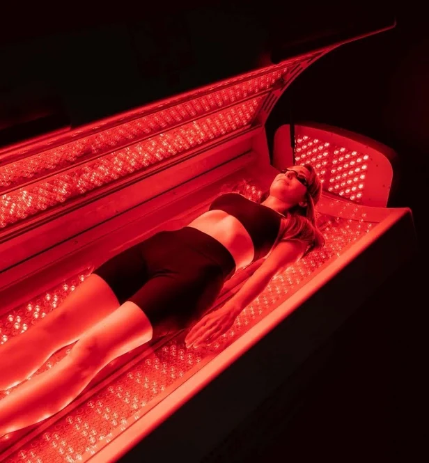 Woman laying in a red light thepary bed