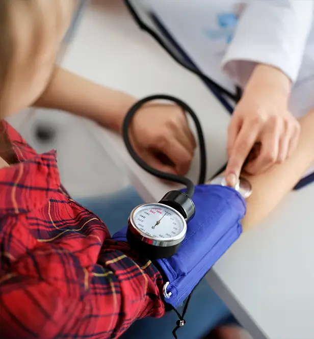 woman getting blood pressure measured by doctor during physical exam
